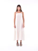 Vestido largo color crudo, con breteles finos y volados en el ruedo.