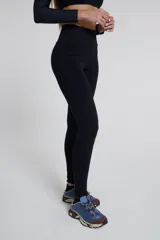Calza larga negra de tiro alto, confeccionada en tejido de poliamida y elastano.