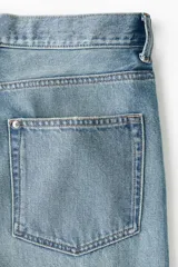 Jeans de cinco bolsillos en denim de algodón rígido, color celeste claro con efecto desgastado. Modelo de corte holgado de cadera a bajo con pierna amplia y tiro caído.