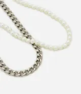 Set de dos collares: uno de cadena plateada de eslabones gruesos y otro de perlas sintéticas.