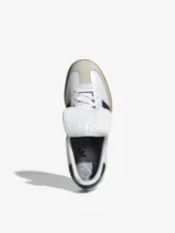 Zapatillas Adidas Samba LT blancas con las tres tiras negras y suela de goma color caramelo.