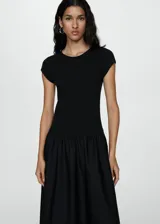 Vestido midi verde oliva con corte a la cintura y falda amplia. El cuerpo es de tejido de punto ajustado y la falda es de algodón. Tiene mangas cortas y cuello redondo.