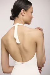 Malla enteriza color crudo, con escote halter y espalda descubierta.