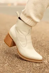 Botas cortas de cuero negro con detalle de punta fina redondeada y taco cuadrado de madera.