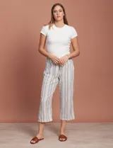 Pantalón capri de lino color blanco con rayas verticales azules y marrones, con cintura elástica ajustable con cordón.