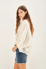 Camisa amarilla de algodón con corte amplio, cuello redondo y mangas 3/4 con puños elásticos.