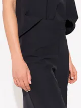 Pantalón negro de corte amplio, largo midi y cintura alta.