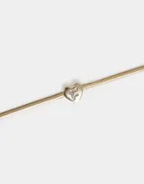 Pulsera dorada de cadena cola de ratón con dije de corazón adornado con strass y cierre de mosquetón.