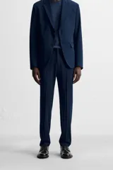 Pantalón de vestir negro slim fit, confeccionado en tejido con viscosa. Cuenta con bolsillos frontales y traseros de vivo. El cierre es frontal con cremallera y botón.