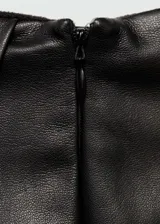 Minifalda negra de cuero sintético con diseño cruzado y cierre lateral invisible.