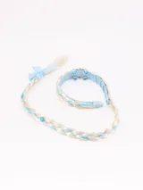 Vincha celeste con trenza blanca y celeste, decorada con strass y un lazo celeste.