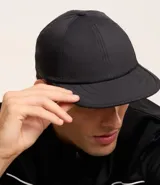 Gorra negra de poliamida con visera curva, protección UV e impermeable.