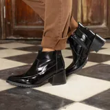 Botas cortas de cuero vacuno negro charol, con cierre lateral YKK, taco de madera foliado en cuero de 6cm y suela de goma.