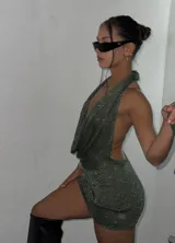 Minivestido verde con brillos, escote halter y espalda descubierta.
