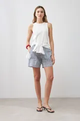 Bermuda de tiro alto con estampado de rayas verticales azules y blancas, con bolsillos laterales y cierre frontal con botón y cremallera.