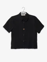 Camisa negra de mangas cortas con cuello clásico y cierre frontal con botones.
