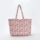 Bolso shopper acolchado con estampado floral en tonos rosa y beige, con doble asa de hombro.
