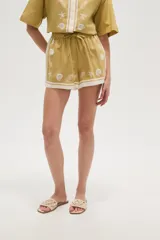 Short de viscosa color mostaza con estampado de motivos marinos en blanco, cintura elastizada con cordón y terminación con ribete blanco.