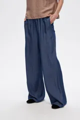 Pantalón azul de lyocell, de corte ancho y tiro alto, con cintura elastizada y bolsillos laterales.