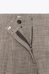 Bermuda color gris con estampado a cuadros, de tiro alto con pinzas delanteras, bolsillos frontales y falsos bolsillos con solapa en la espalda.