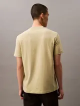 Remera color arena de corte regular, cuello redondo y manga corta. Estampado frontal con el logo de Calvin Klein Jeans en color blanco.