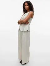 Pantalón sastrero de corte wide leg color beige, tiro medio, con bolsillos laterales, presillas para cinturón y detalle de pliegues en el frente.