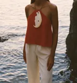 Top rojo tomate de cuero con pieza de nácar en el centro.