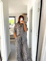 Conjunto de camisa de manga corta y pantalón palazzo acampanado con estampado de leopardo en tonos blanco, gris y negro.