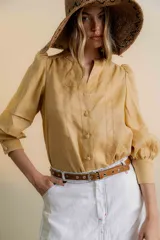 Camisa color ocre de lino con mangas largas abullonadas, cuello mao y cierre frontal con botones.