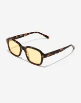 Lentes de sol unisex Hawkers modelo Twist, con montura cuadrada de carey marrón y lentes amarillas.