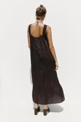 Vestido midi color marrón oscuro, con tirantes anchos y escote recto. Presenta detalle de puntilla en el escote y bordados a tono en el ruedo.