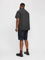 Short chino azul marino de lino y algodón, corte relajado, cintura media con elástico y cordón ajustable, bolsillos frontales y traseros.