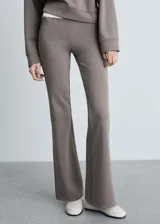 Pantalón largo acampanado color marrón topo, de tejido de punto con cintura elástica y tiro medio.