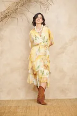 Vestido midi color amarillo con estampado floral, escote cruzado, mangas cortas y falda con volados.