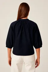 Camisa negra de corte holgado con cuello mao y mangas abullonadas 3/4.
