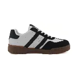 Zapatillas urbanas de cuero negro con tres tiras blancas en el lateral y suela marrón.