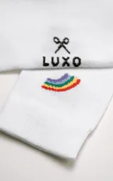 Medias blancas de algodón con puño acanalado y logo de la marca en el tobillo. Presentan un pequeño arcoíris bordado en el lateral superior.