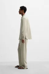 Pantalón negro regular fit confeccionado en tejido de lino. Cintura ajustable con cordón interior, bolsillos frontales y detalle de bolsillos traseros de vivo.