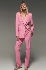 Blazer entallada color rosa, confeccionada en mezcla de viscosa. Tiene cuello solapa con muescas, manga larga, bolsillos con solapa en el delantero, forro interior a contraste y cierre frontal con botón.