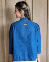 Camisa color crudo, de corte recto, con cuello mao y mangas 3/4 con detalle de puño en contraste.