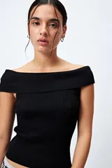 Top tejido color blanco con escote bardot que deja los hombros al descubierto y punto acanalado.