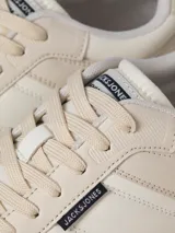 Championes urbanos Jack & Jones modelo Jam, color crema con detalles en blanco. Confeccionados en malla de poliéster y poliuretano, con suela de goma y puntera redonda.