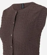 Blusa femenina de corte regular confeccionada en tejido de anarruga texturizado color beige. Presenta cuello redondo, diseño sin mangas y cierre frontal con botones.