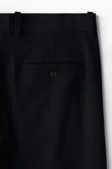 Bermuda negra de sarga suave en mezcla de algodón y lyocell. Modelo con pliegues adelante, cierre con botón, bolsillos laterales ribeteados y bolsillos insertados atrás con botón. Corte estándar para una silueta clásica y cómoda.