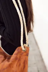 Cartera tipo tote bag de cuero color marrón con efecto desgastado, con asas trenzadas de cuero crudo.