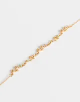 Collar corto dorado con cadena de eslabones y apliques de hojas y flores esmaltadas en tonos pastel.
