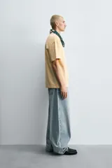 Camiseta color arena de algodón compacto, corte recto, cuello redondo y mangas cortas.