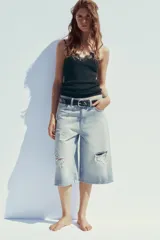 Camiseta negra de algodón con tirantes finos y escote en pico con detalle de encaje.