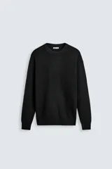 Sweater negro de punto perlado con cuello redondo y manga larga.