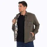 Sobrecamisa Merrell color verde oliva, confeccionada en algodón suave y resistente. Cuenta con cuello clásico, cierre frontal con botones a presión, bolsillo de parche en el pecho izquierdo con etiqueta de la marca y puños con botón.